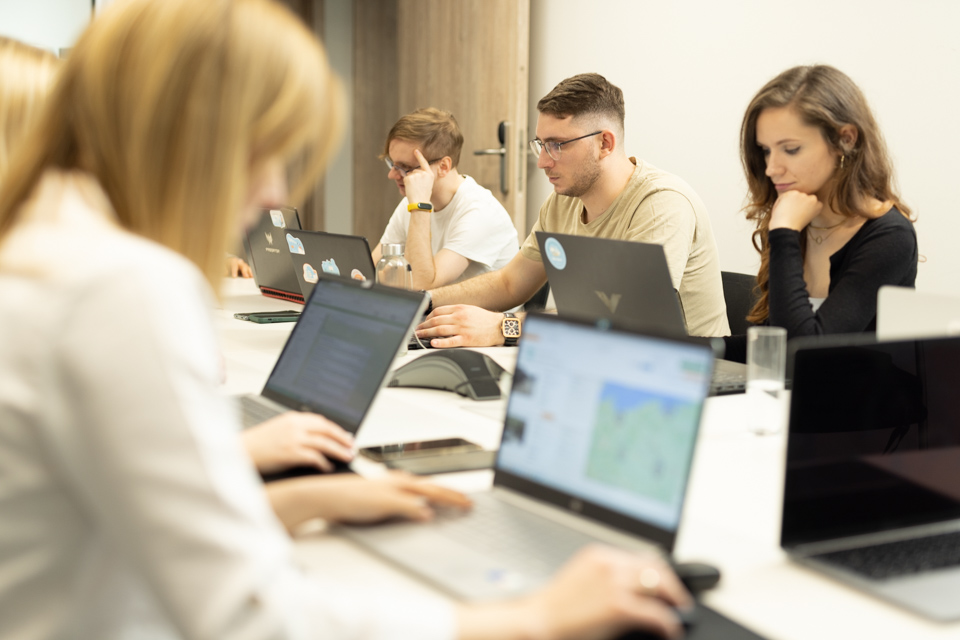 Zespół planujący kampanię outdoorową przy laptopach